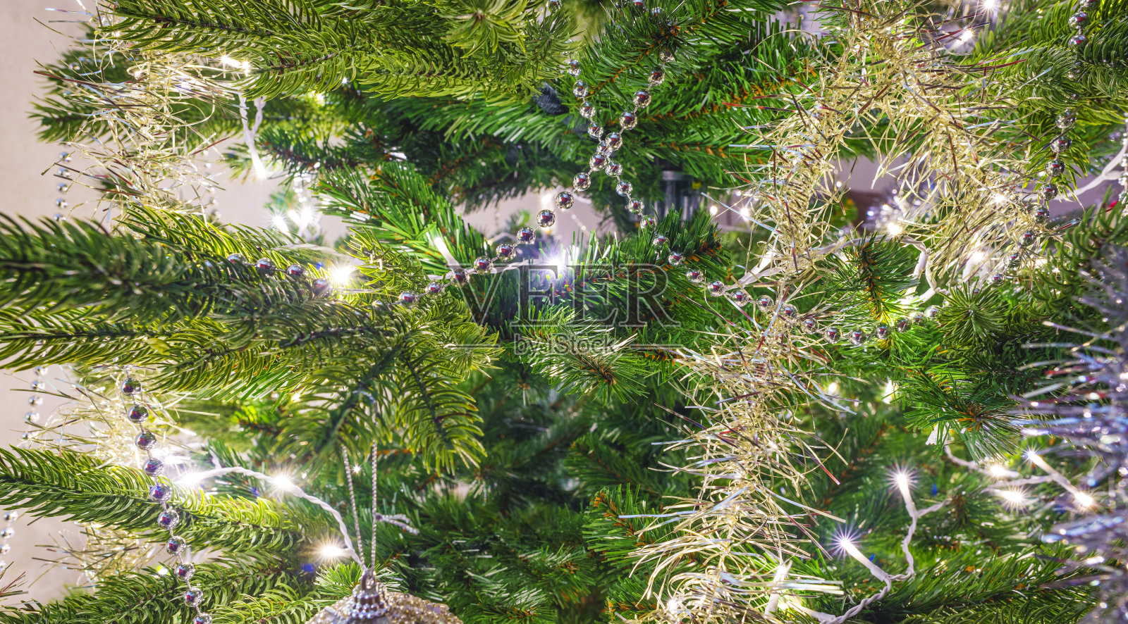 装饰照明的圣诞树在室内用灯和花环照片摄影图片