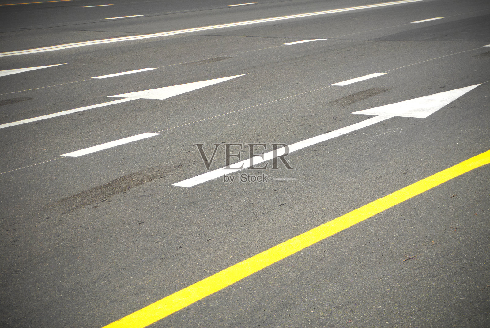 柏油路上的方向箭头和线。照片摄影图片