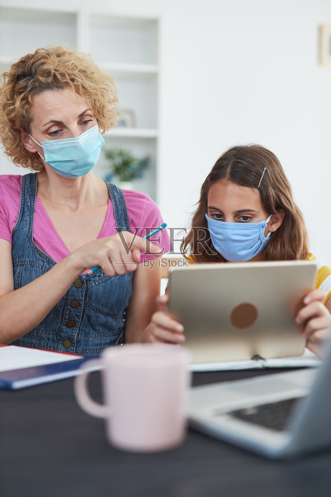 儿童在家学习教育，在家上学，在病毒、流感和季节性流行的时候与私人教师/母亲。照片摄影图片