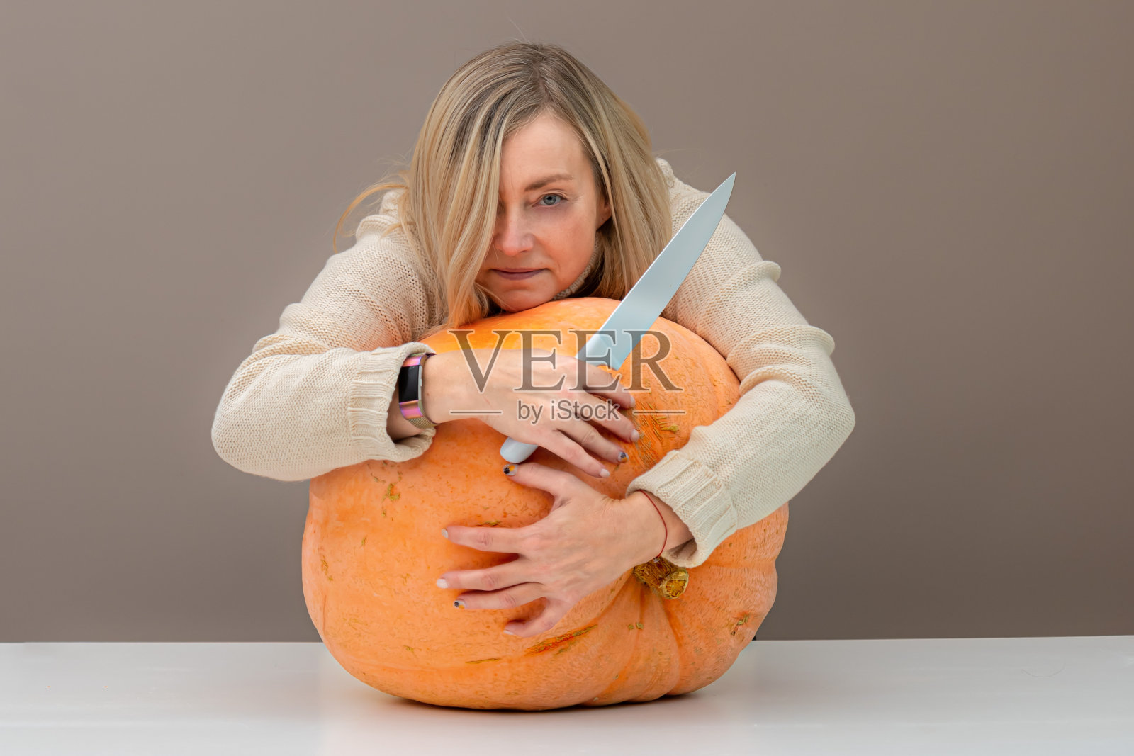 女人拿着一把大南瓜刀，抱着健康有机素食的理念照片摄影图片