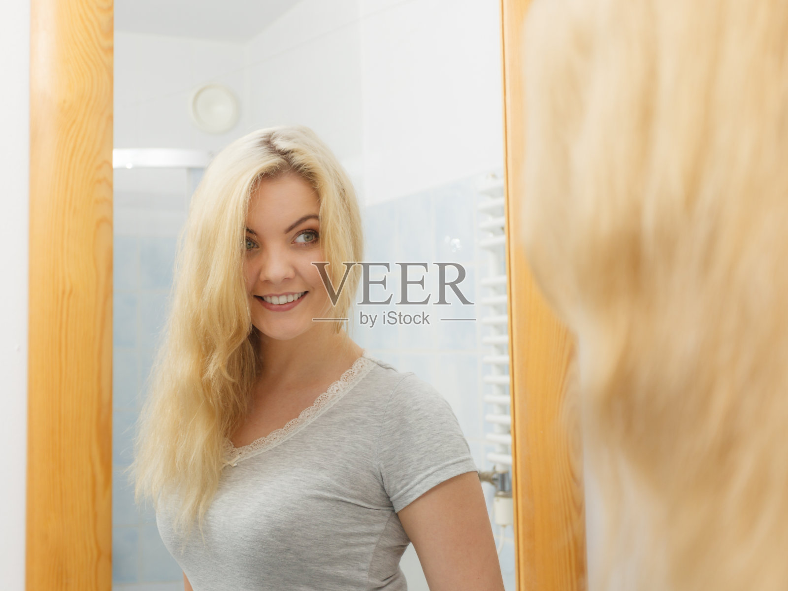 浴室里的女人看着镜子照片摄影图片