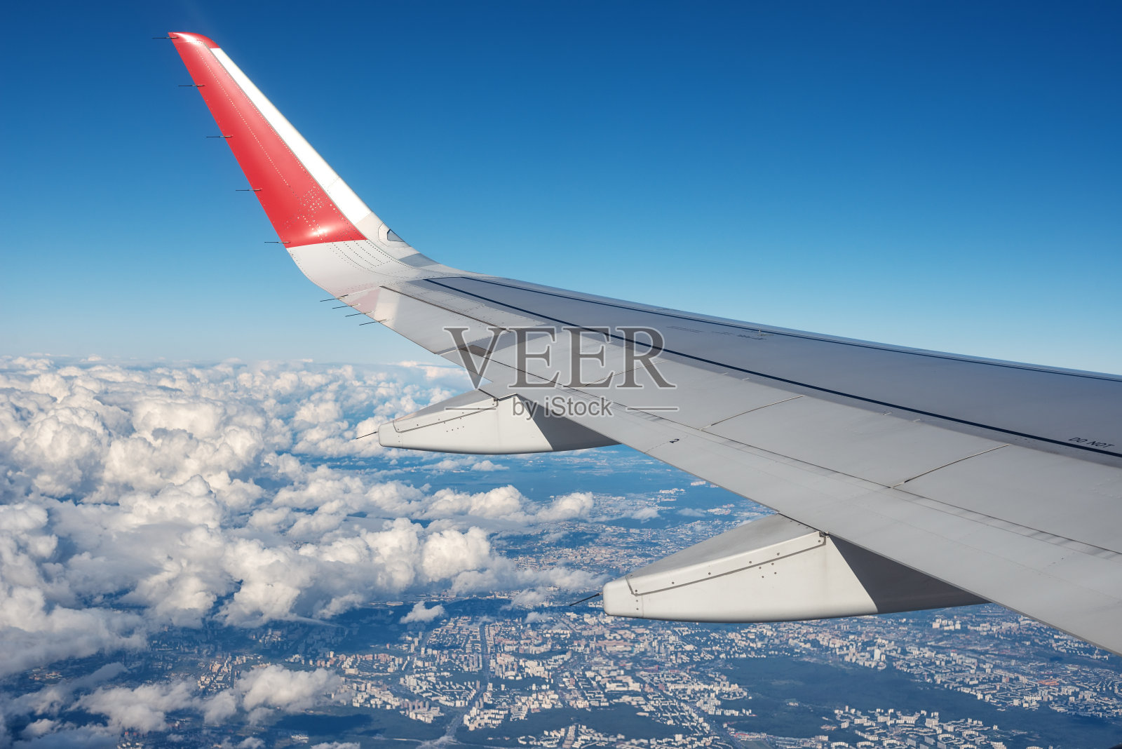 从飞机上鸟瞰莫斯科郊外的云下有着灰红色的翅膀和蓝色的天空照片摄影图片