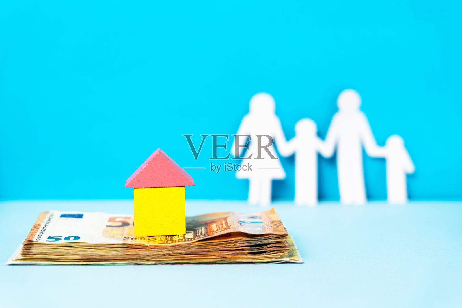 紧靠木房子的上面堆着钱或欧元钞票，以家庭为背景，带着拷贝空间买房保险和储蓄房地产贷款的概念照片摄影图片