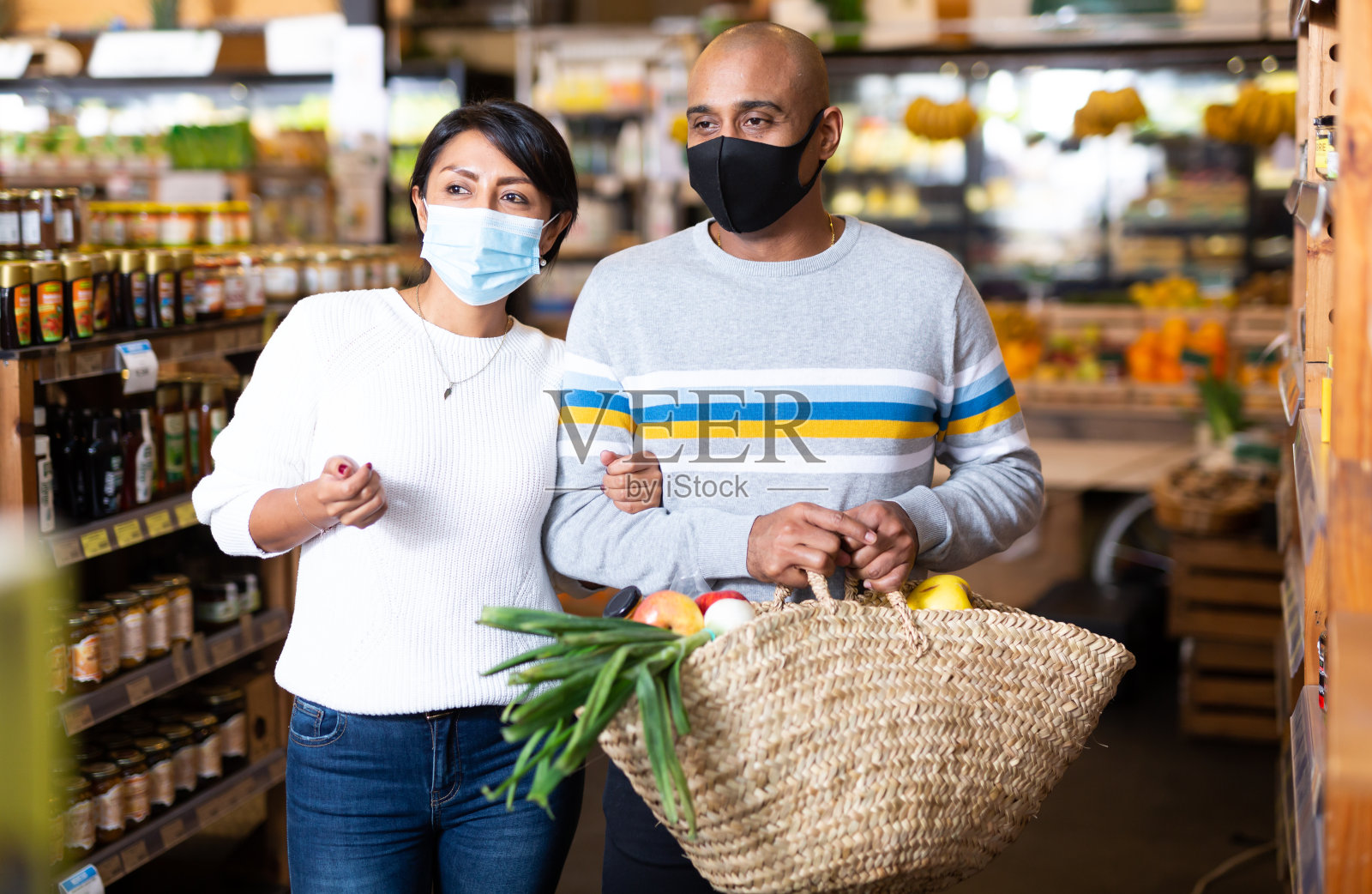 西班牙夫妇戴着防护面具在杂货店购物照片摄影图片