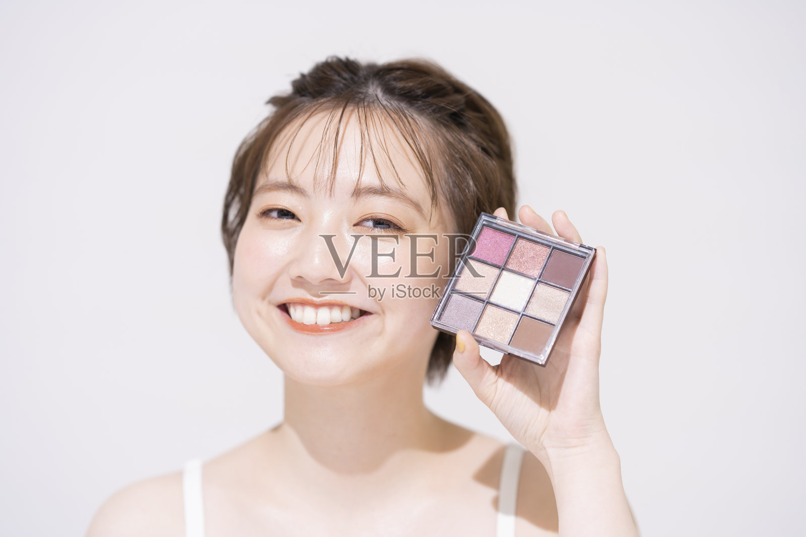 拿着化妆品的年轻女人照片摄影图片