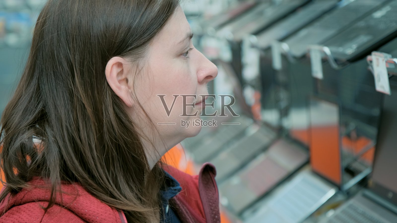 一位女士在超市挑选要买的笔记本电脑照片摄影图片
