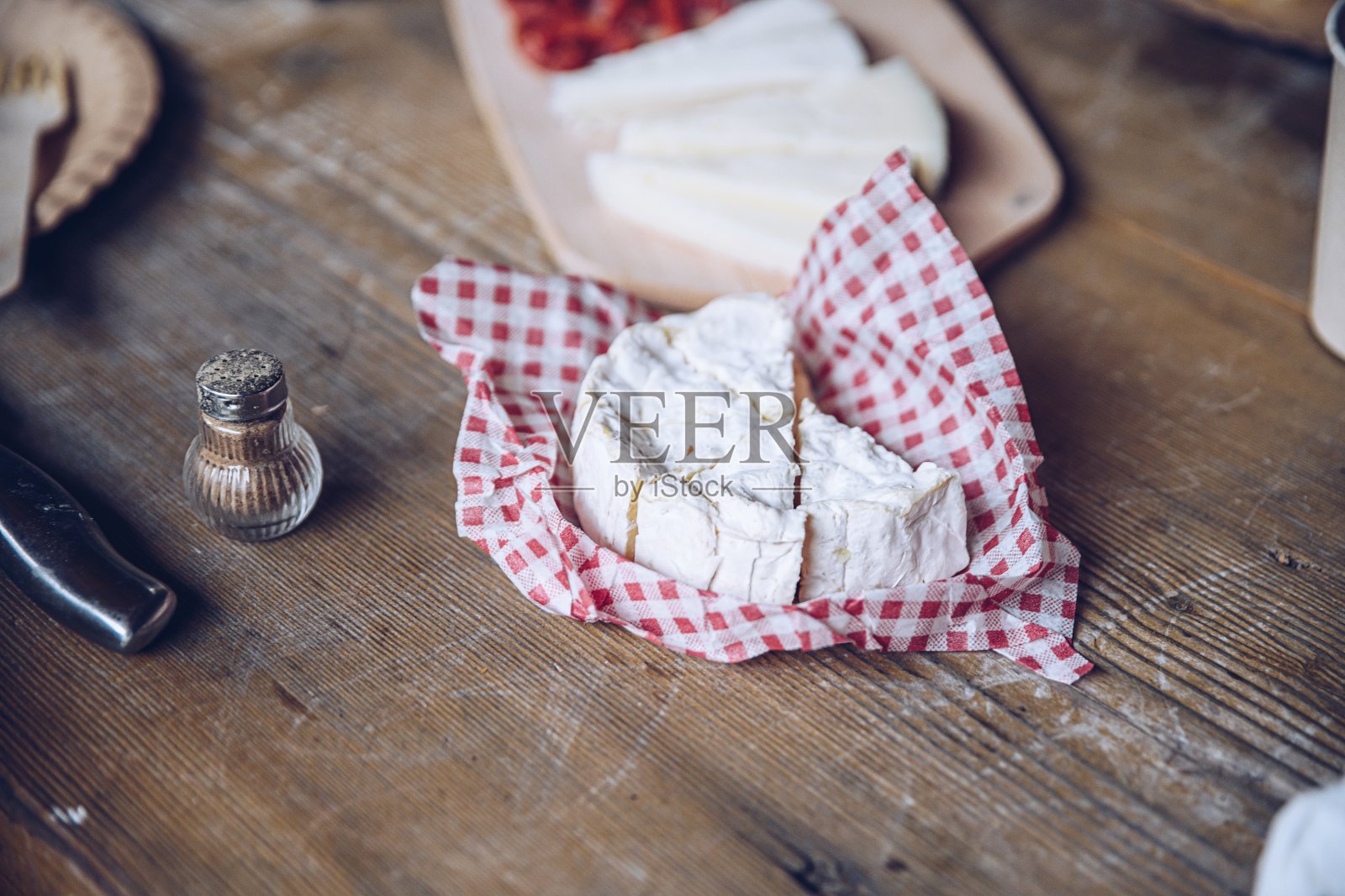 木桌上放着卡巴诺斯香肠和蓝奶酪。照片摄影图片