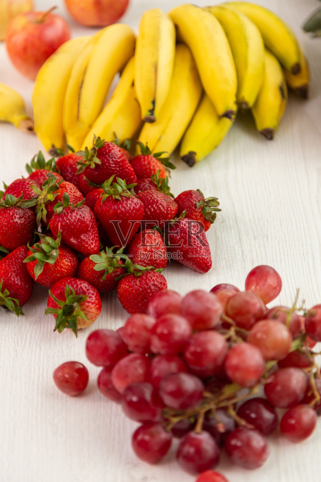 美味的新鲜水果在白色的背景和太阳，菠萝，香蕉，苹果，草莓，葡萄和香蕉，健康的生活方式，工作室风格照片摄影图片