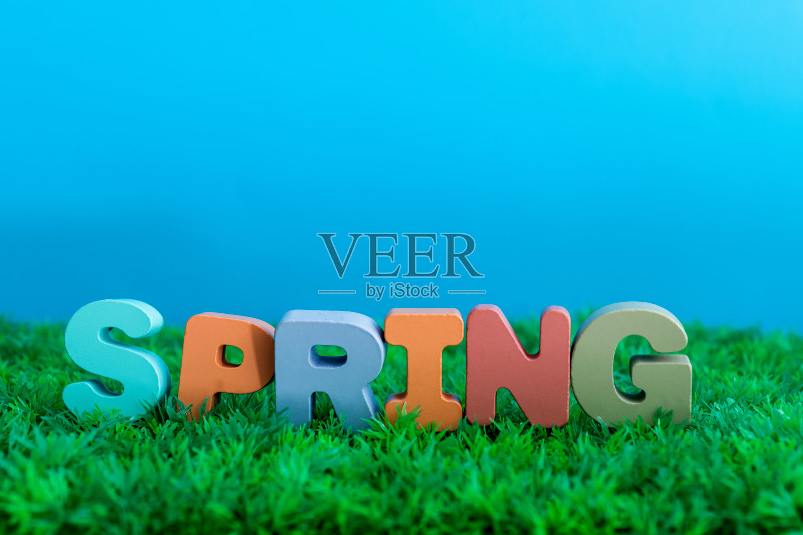 木字春天在绿色草地上照片摄影图片