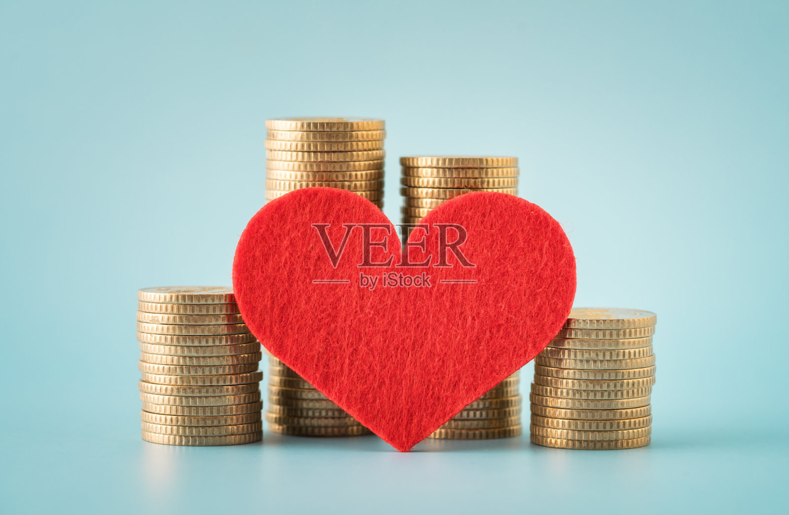 硬币堆和蓝色背景上的心照片摄影图片