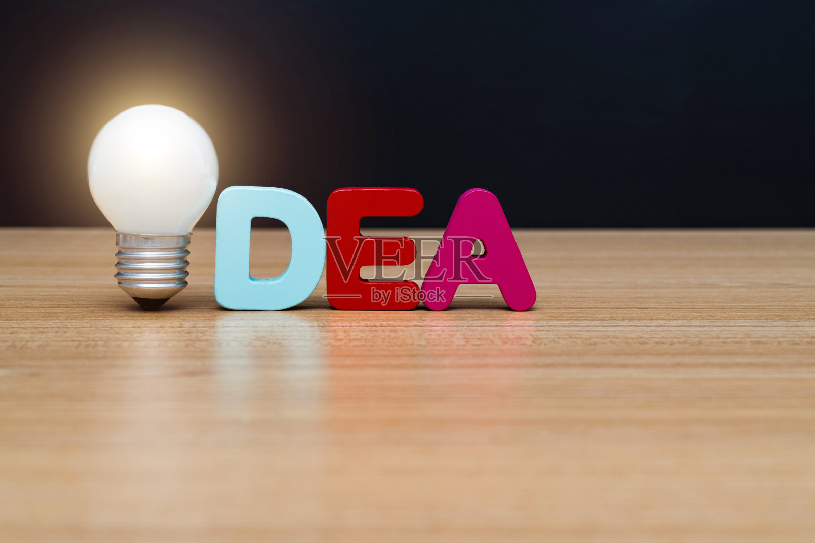 桌上放着灯泡和木字点子照片摄影图片