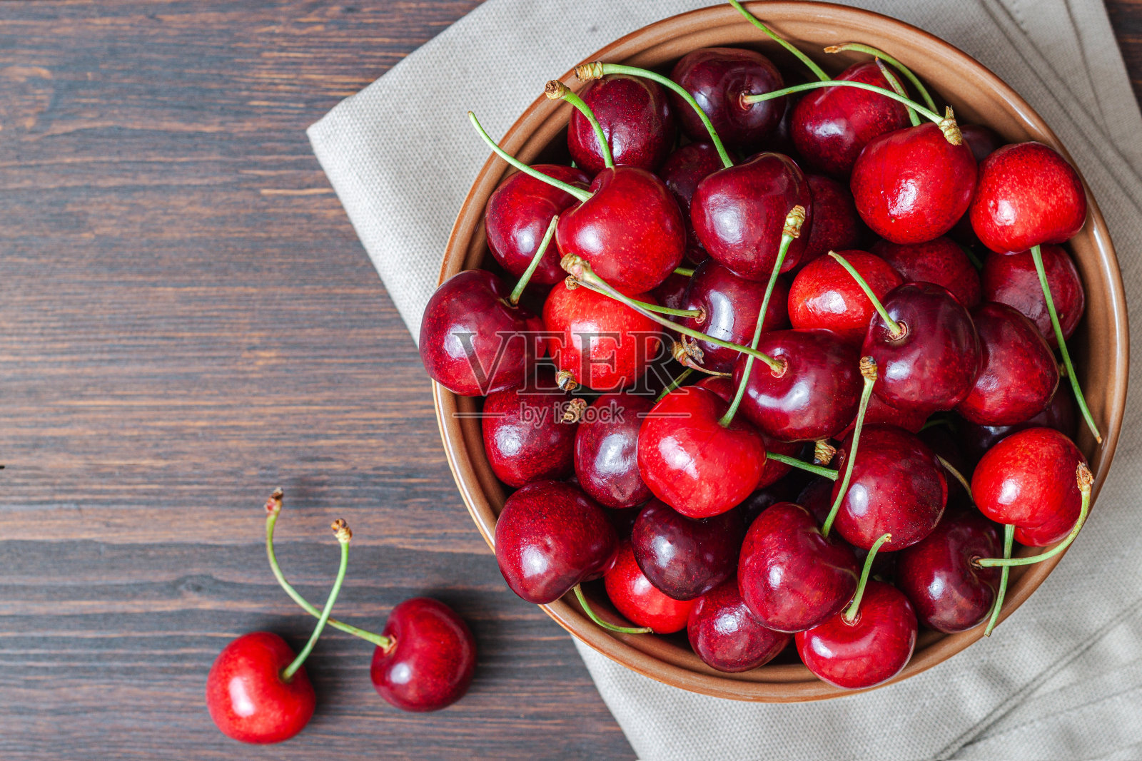 木背景上的樱桃盘碗。照片摄影图片