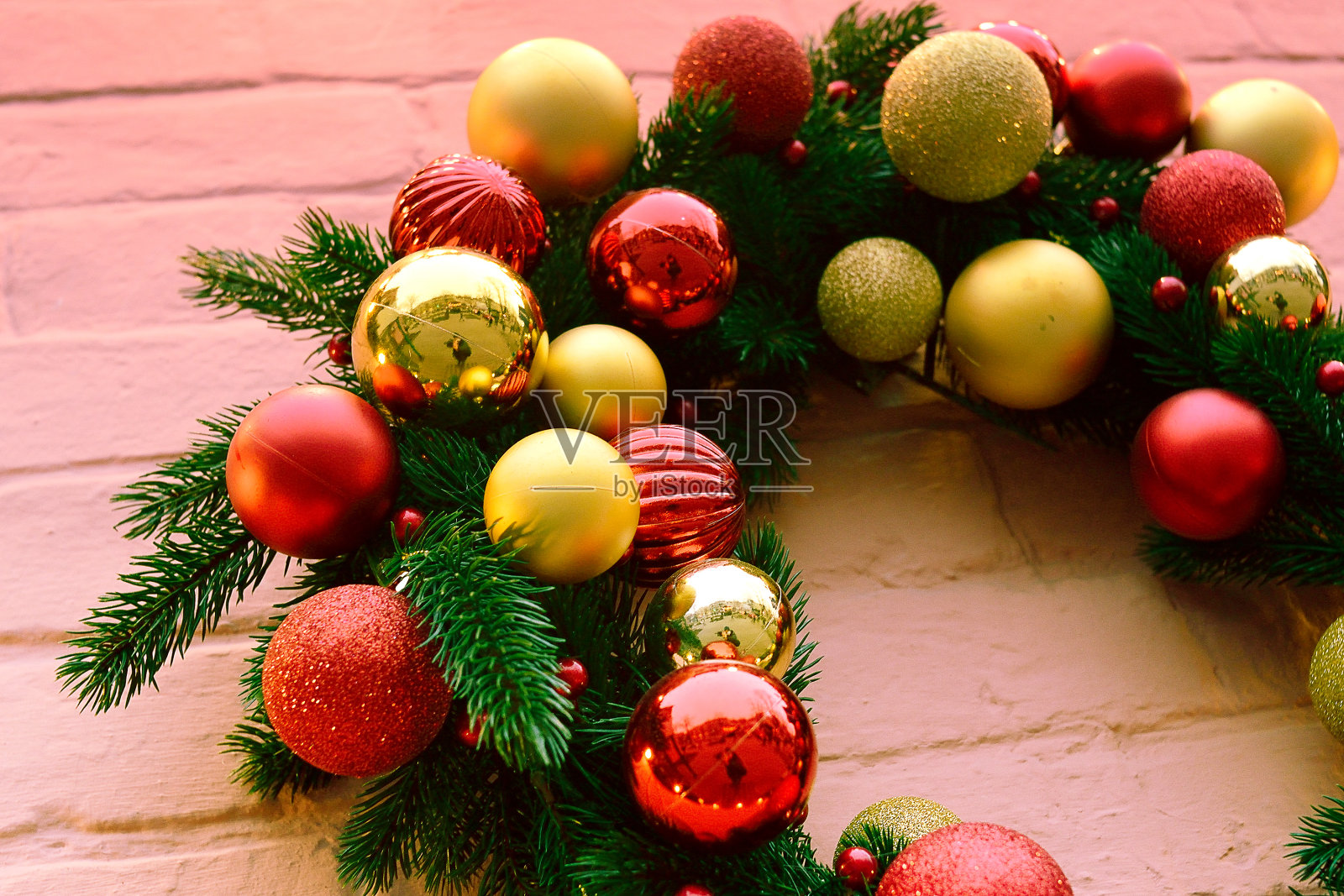 粉色砖墙上的圣诞花环照片摄影图片