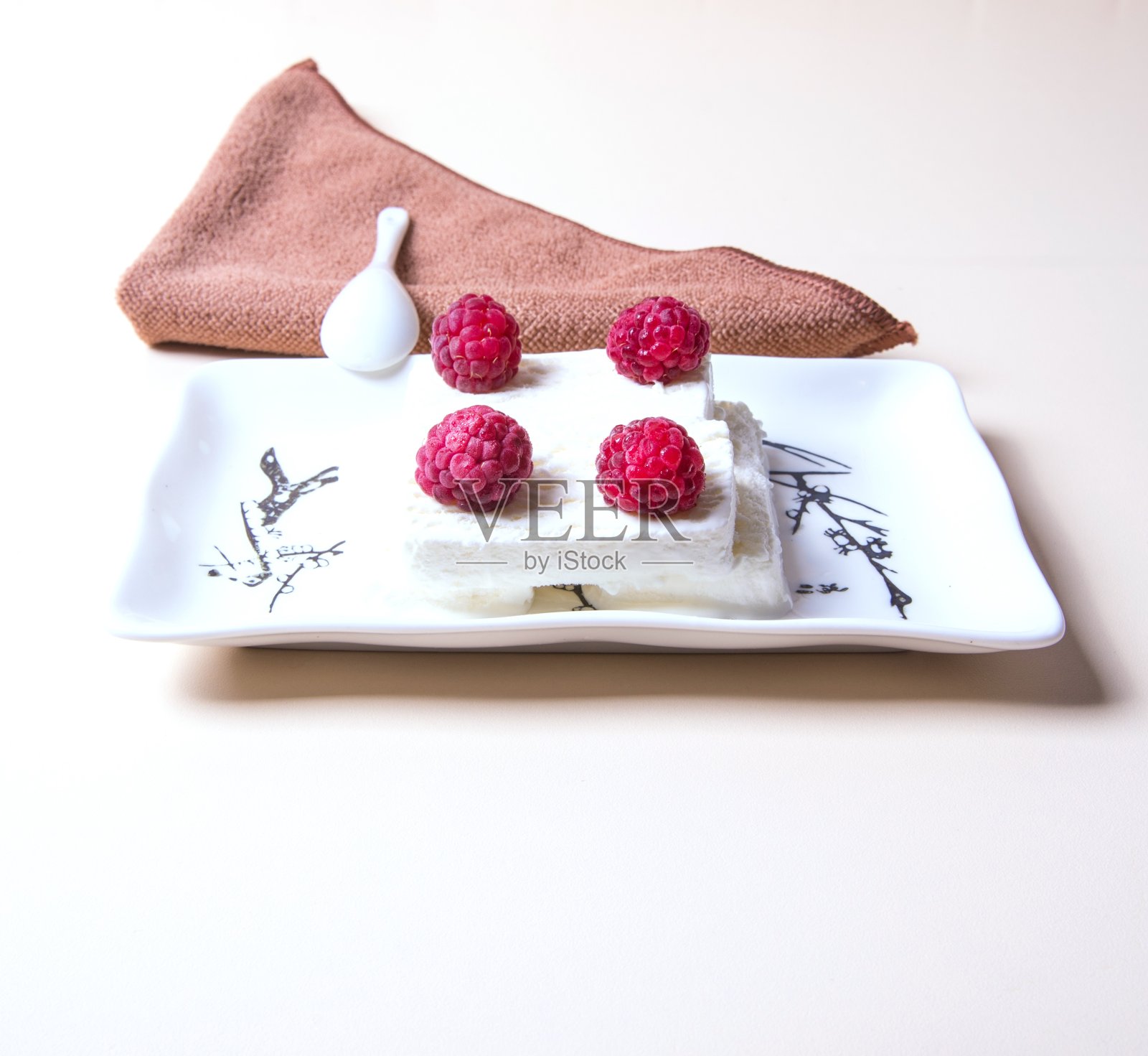 冰淇淋上的一个碟子与覆盆子浆果特写，在一个白色的背景，地方的文字照片摄影图片