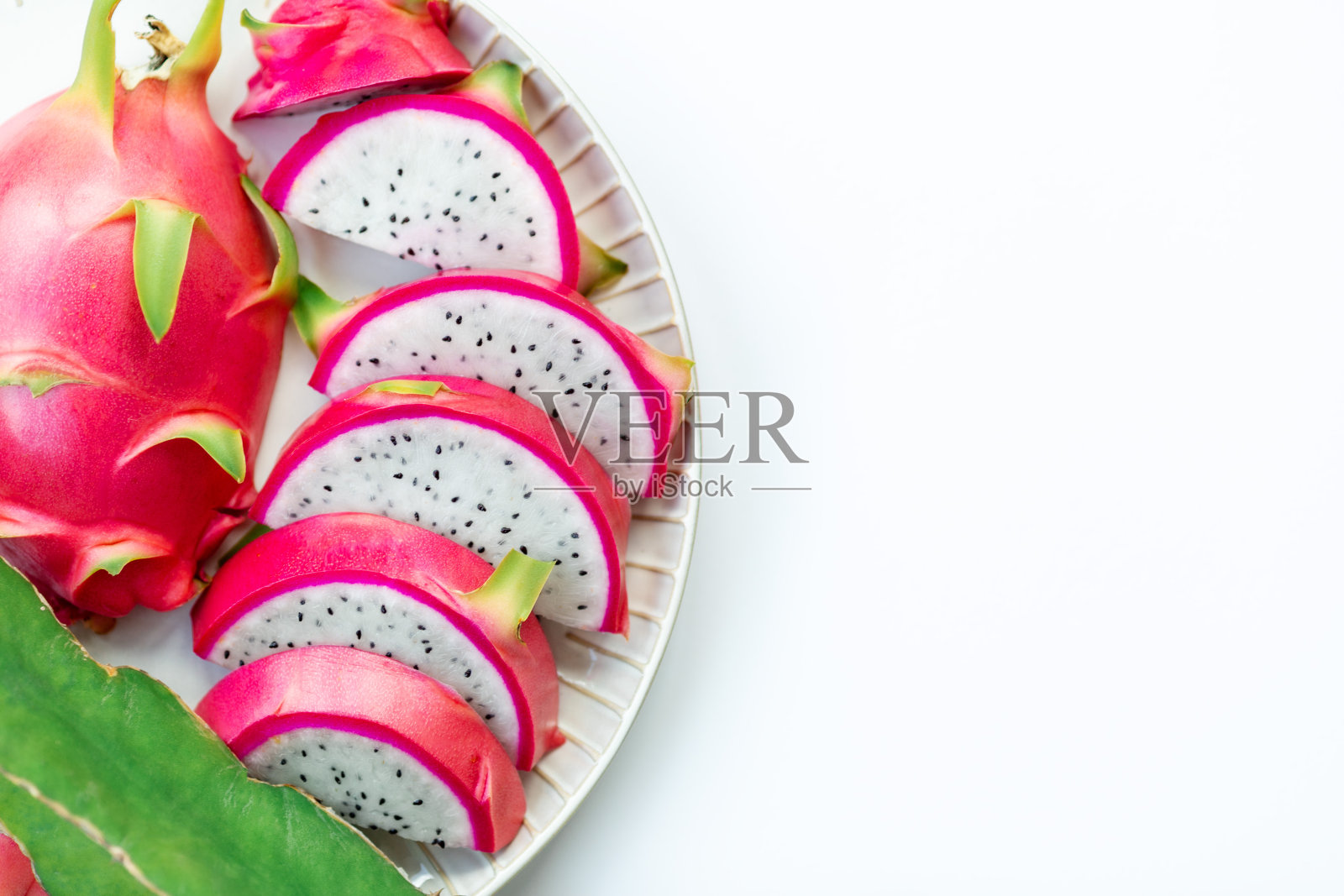 切片的粉红色火龙果盘孤立在白色背景上照片摄影图片
