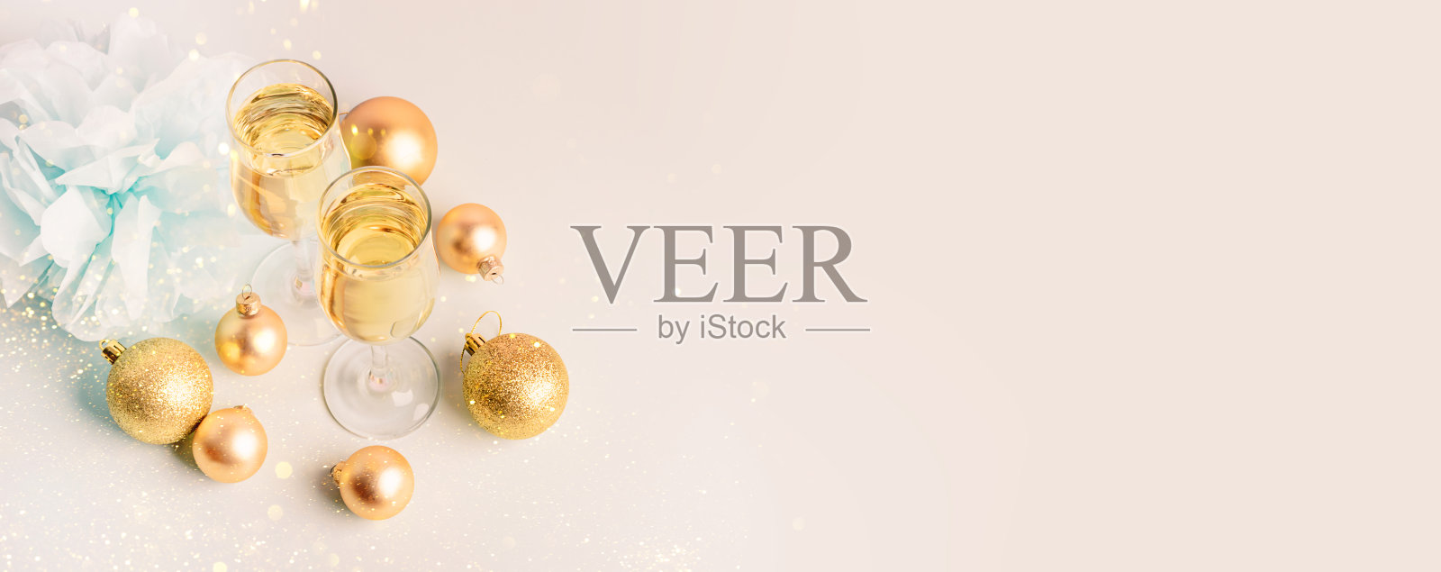 酒杯里的香槟，金色的气球，蛇形的，柔和的粉红色背景照片摄影图片