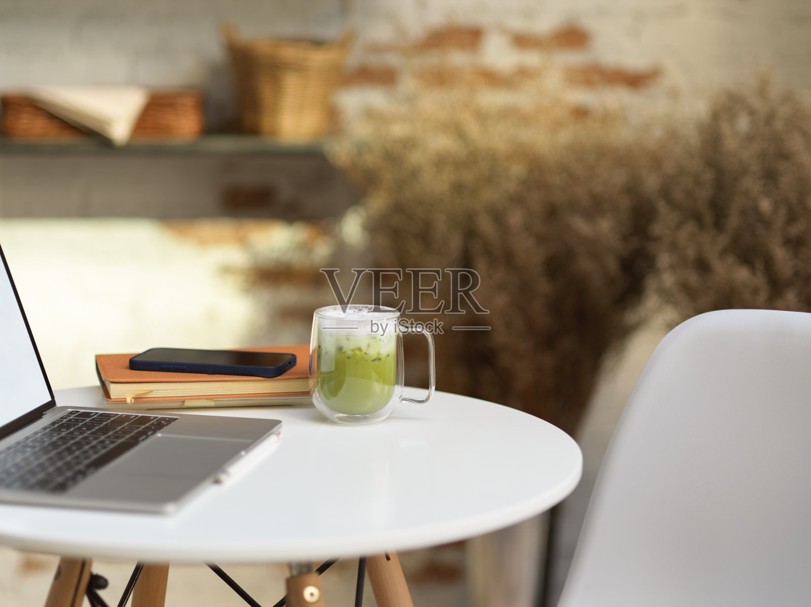 有笔记本电脑、文具和抹茶拿铁的咖啡桌照片摄影图片