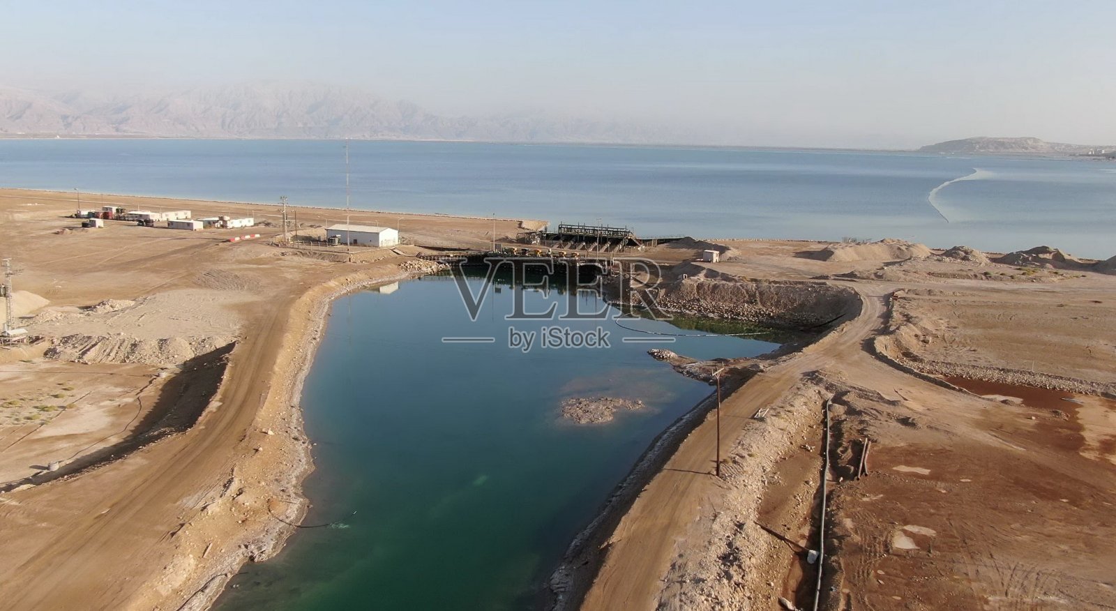 一条向以色列Ein Bokek度假村附近干涸的死海输送盐水的狭窄溪流照片摄影图片