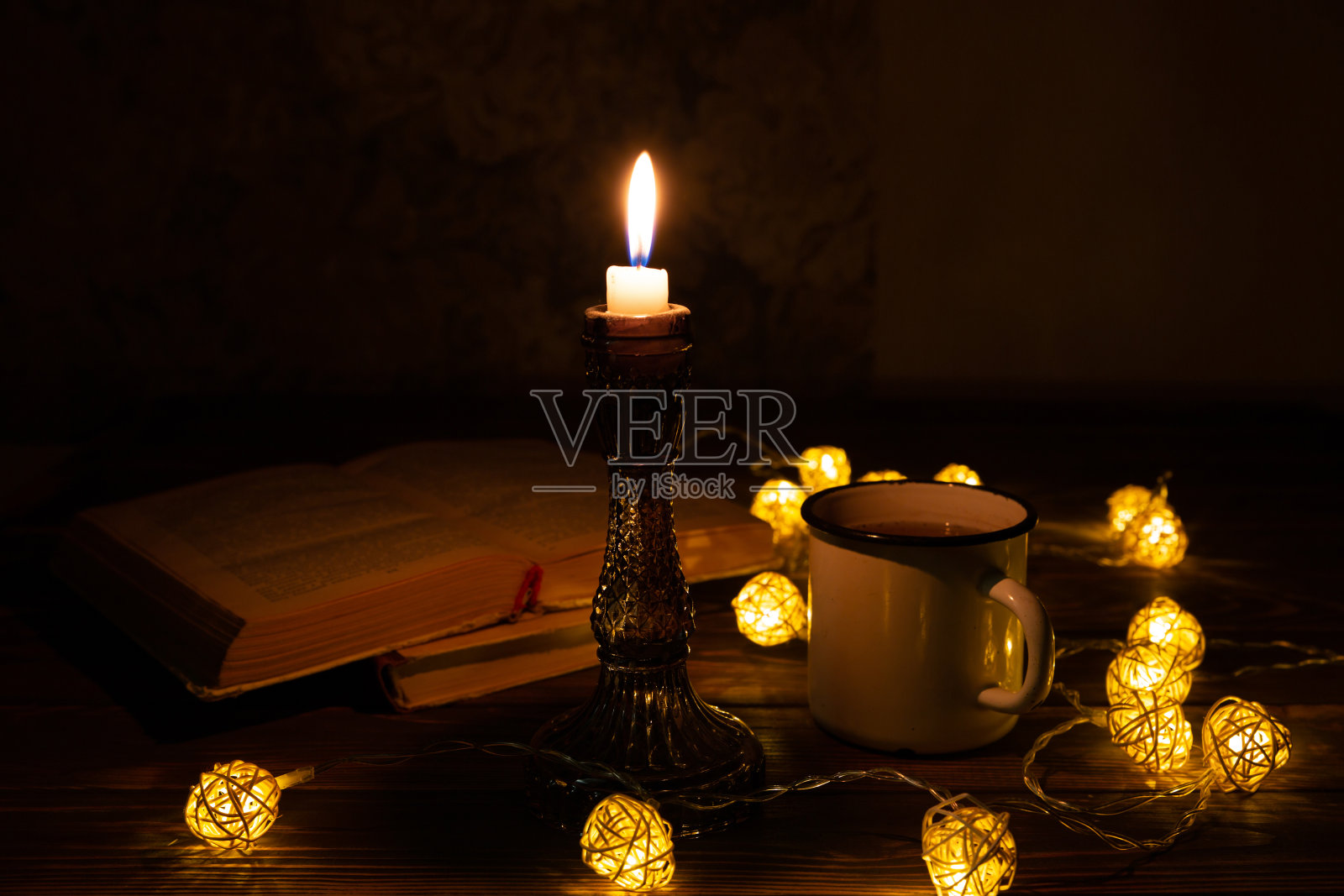 书和热茶杯，舒适的夜晚。假期心情照片与圣诞彩灯。木心和蜡烛。Hygge概念。完美的秋季平铺。照片摄影图片