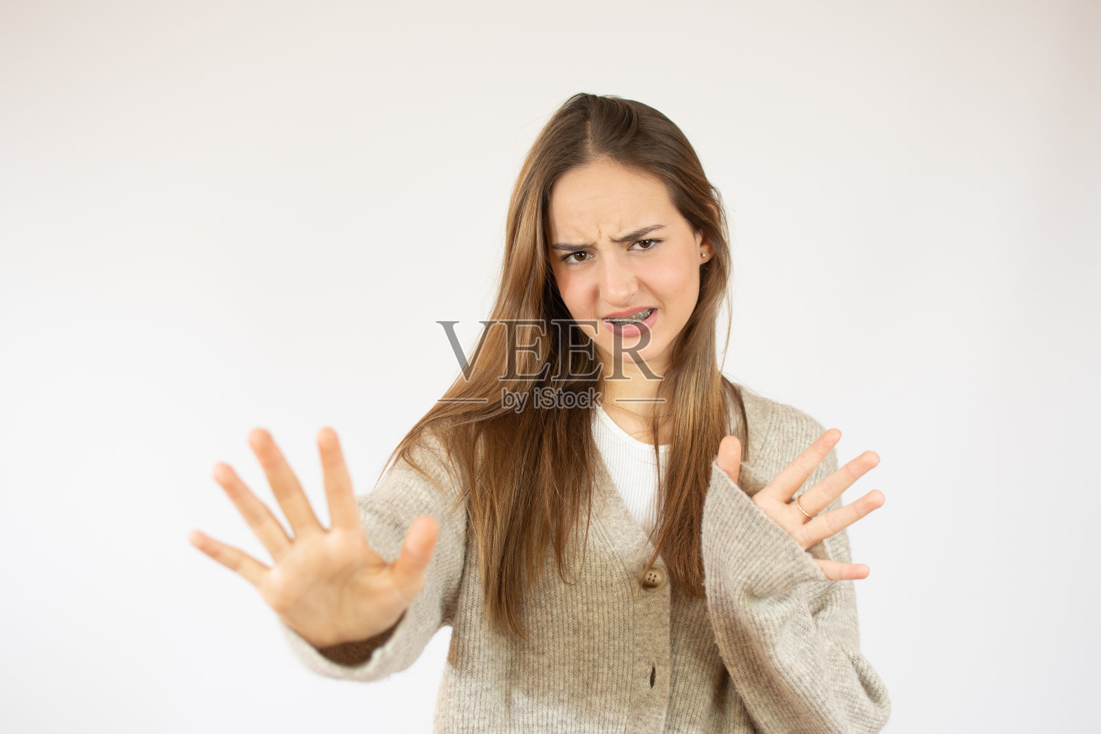 年轻漂亮的女子穿着休闲毛衣害怕和恐惧的表情停止手势与手，在震惊中大叫。恐慌的概念。照片摄影图片