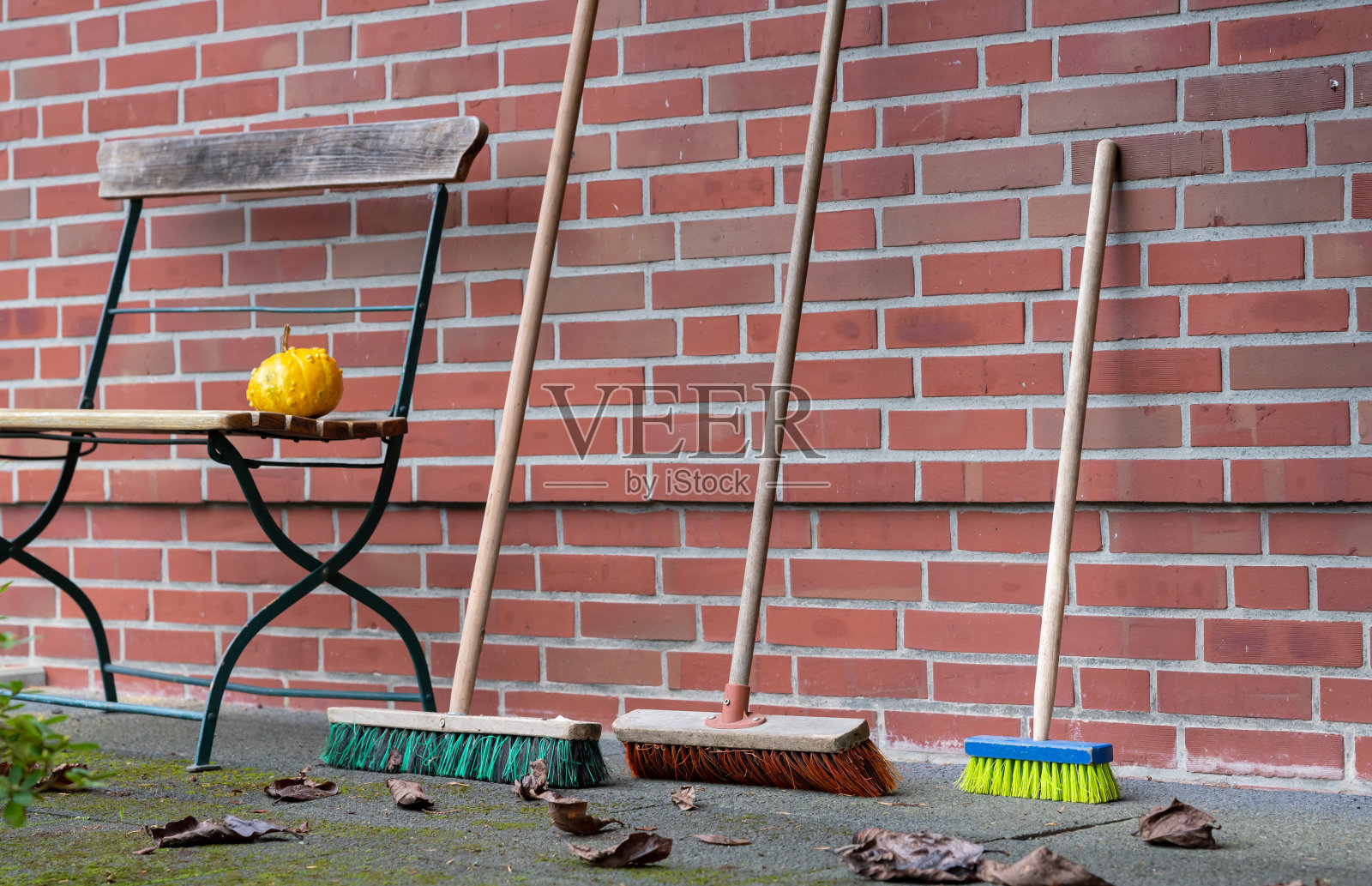 象征着生第一个孩子。两把普通的扫帚和一把儿童用的小扫帚靠在墙上。照片摄影图片