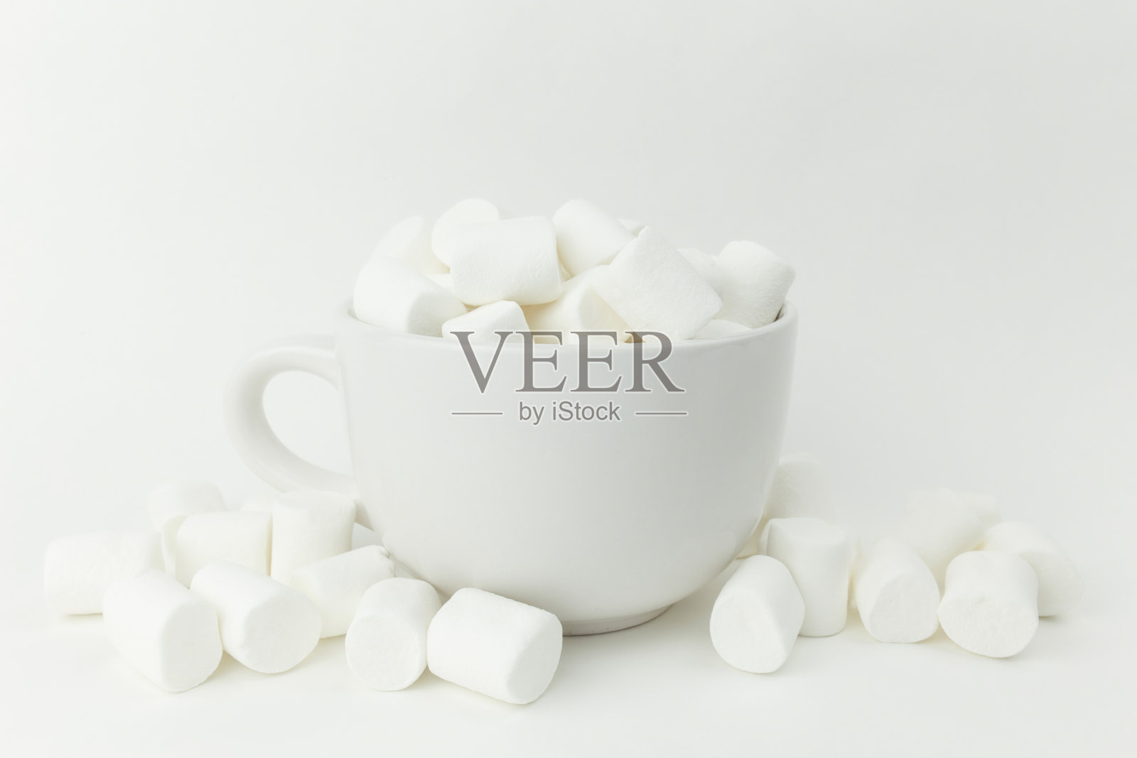 白色背景的杯子里有棉花糖照片摄影图片