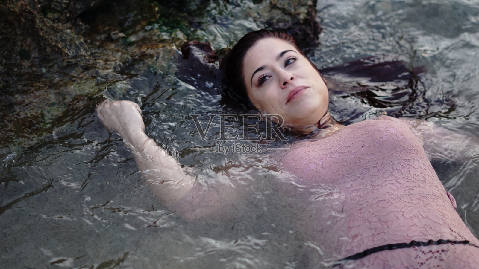 年轻女子半浸在水里照片摄影图片