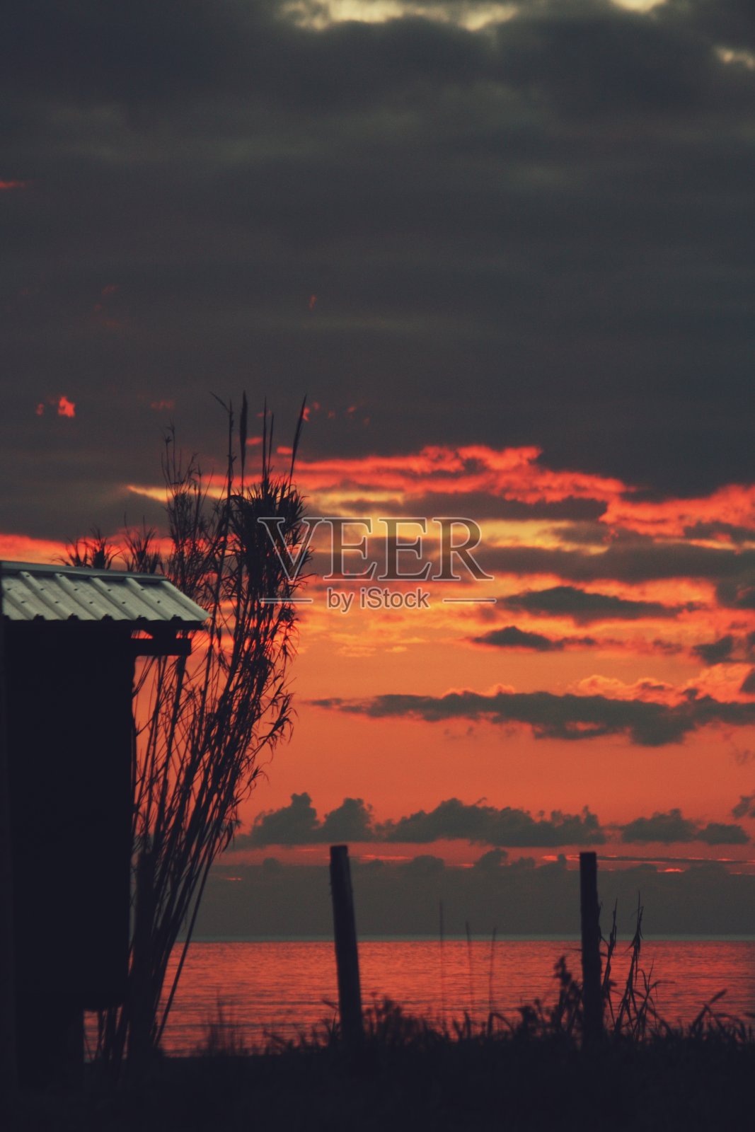 海滩小屋在生气勃勃的海上日落照片摄影图片