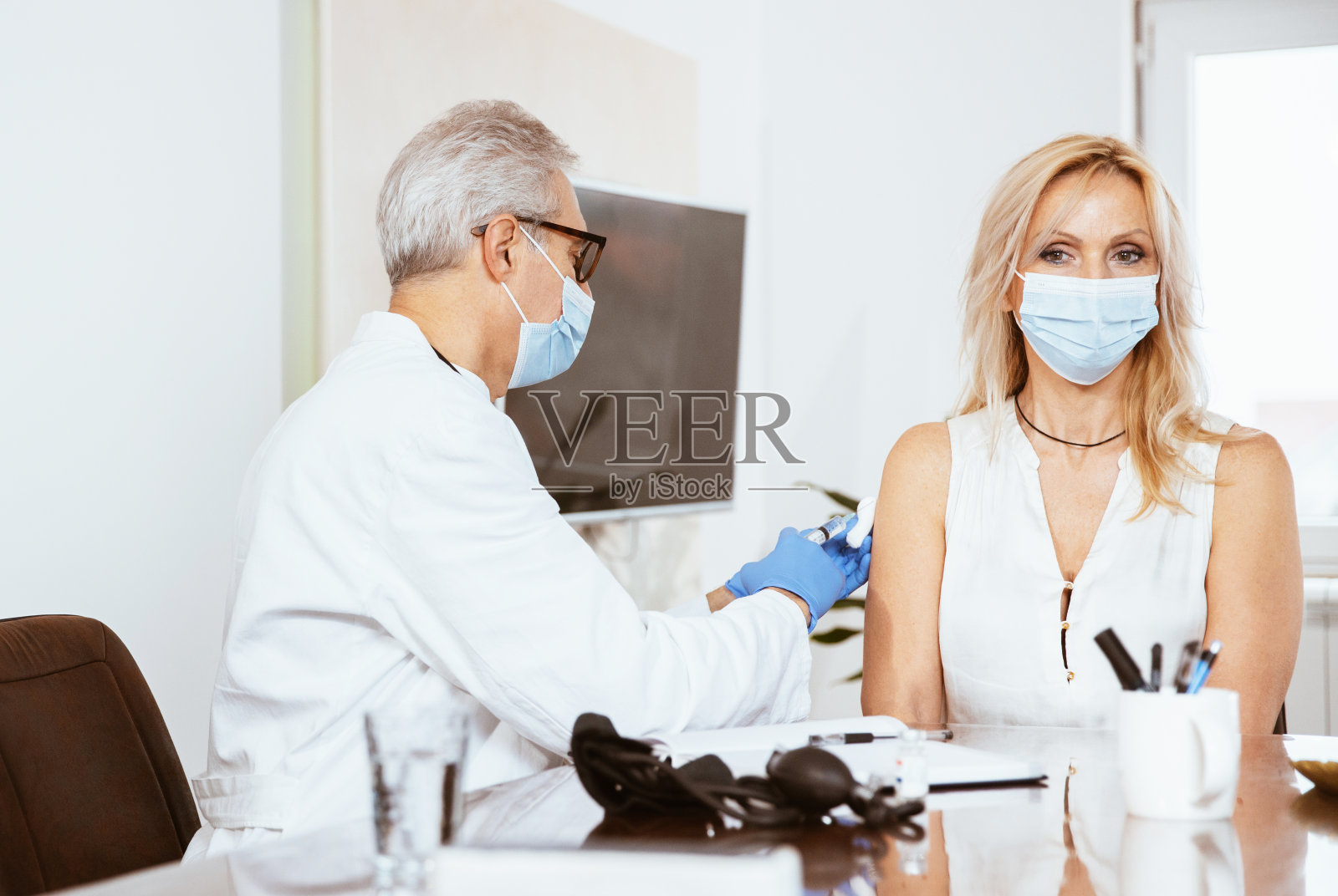 医生接种妇女在医生的办公室照片摄影图片