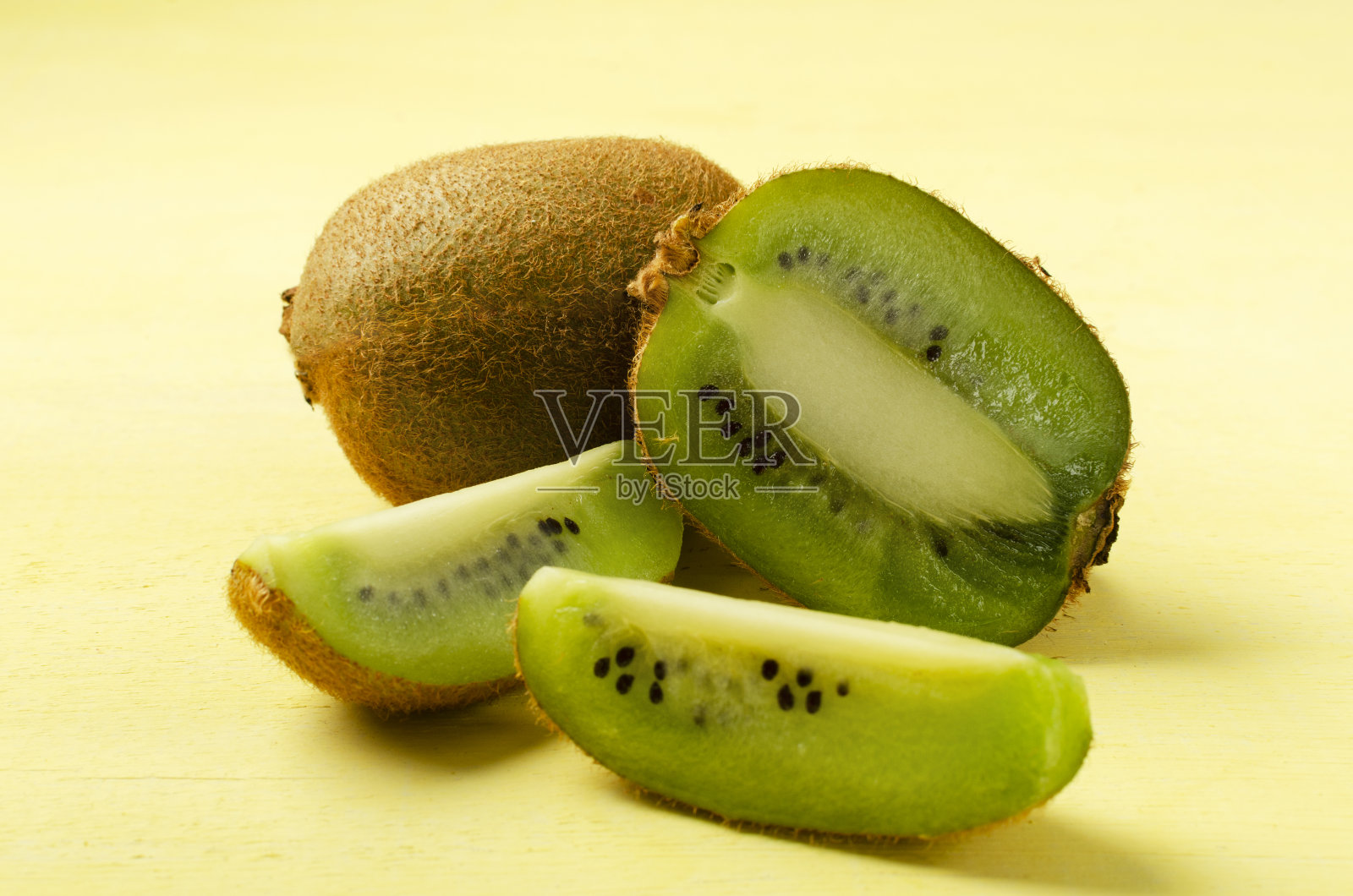 特写的猕猴桃片和整个一个在黄色的背景照片摄影图片
