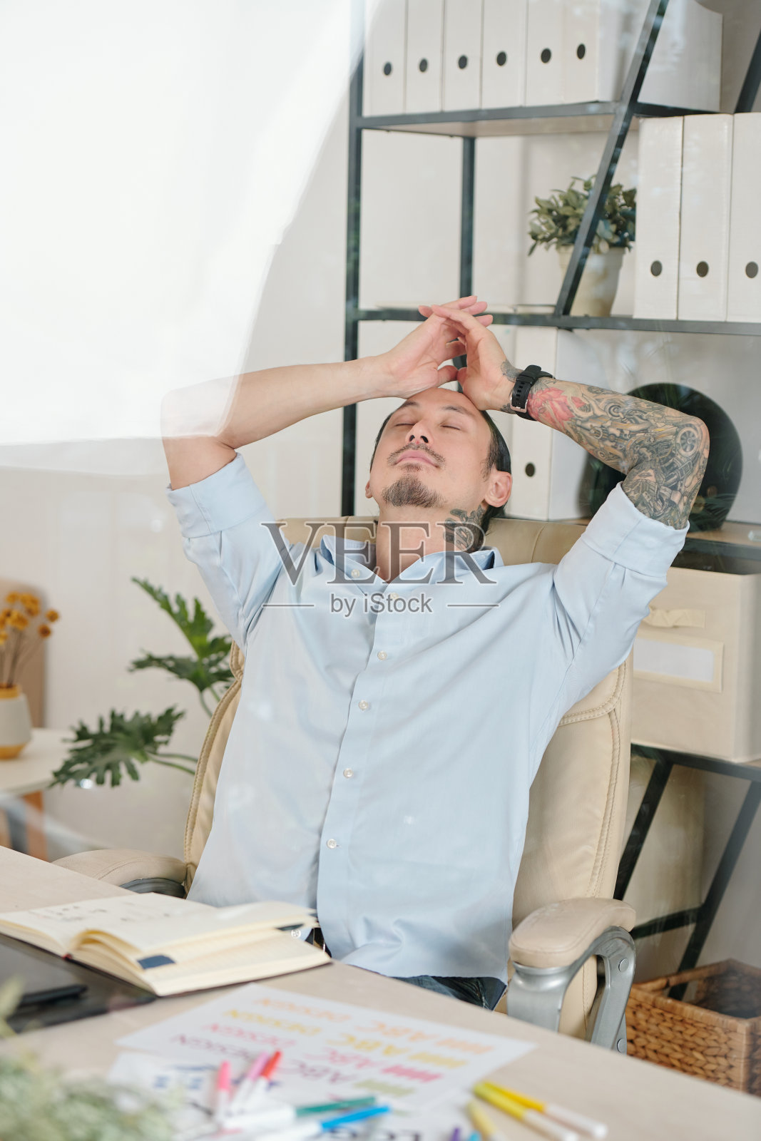 平面设计师靠在椅子上照片摄影图片