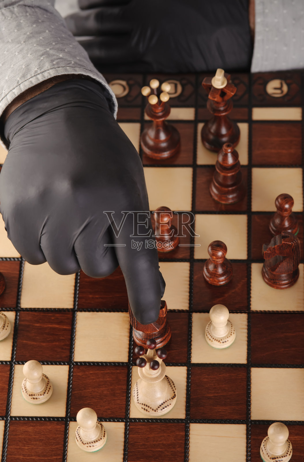 Person in black gloves playing chessю照片摄影图片