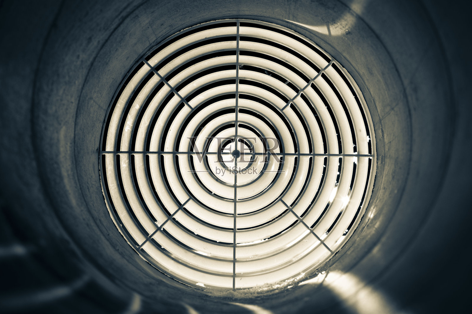 通风格栅扩散器的特写安装在夜间的风管，前面和背景是模糊的照片摄影图片