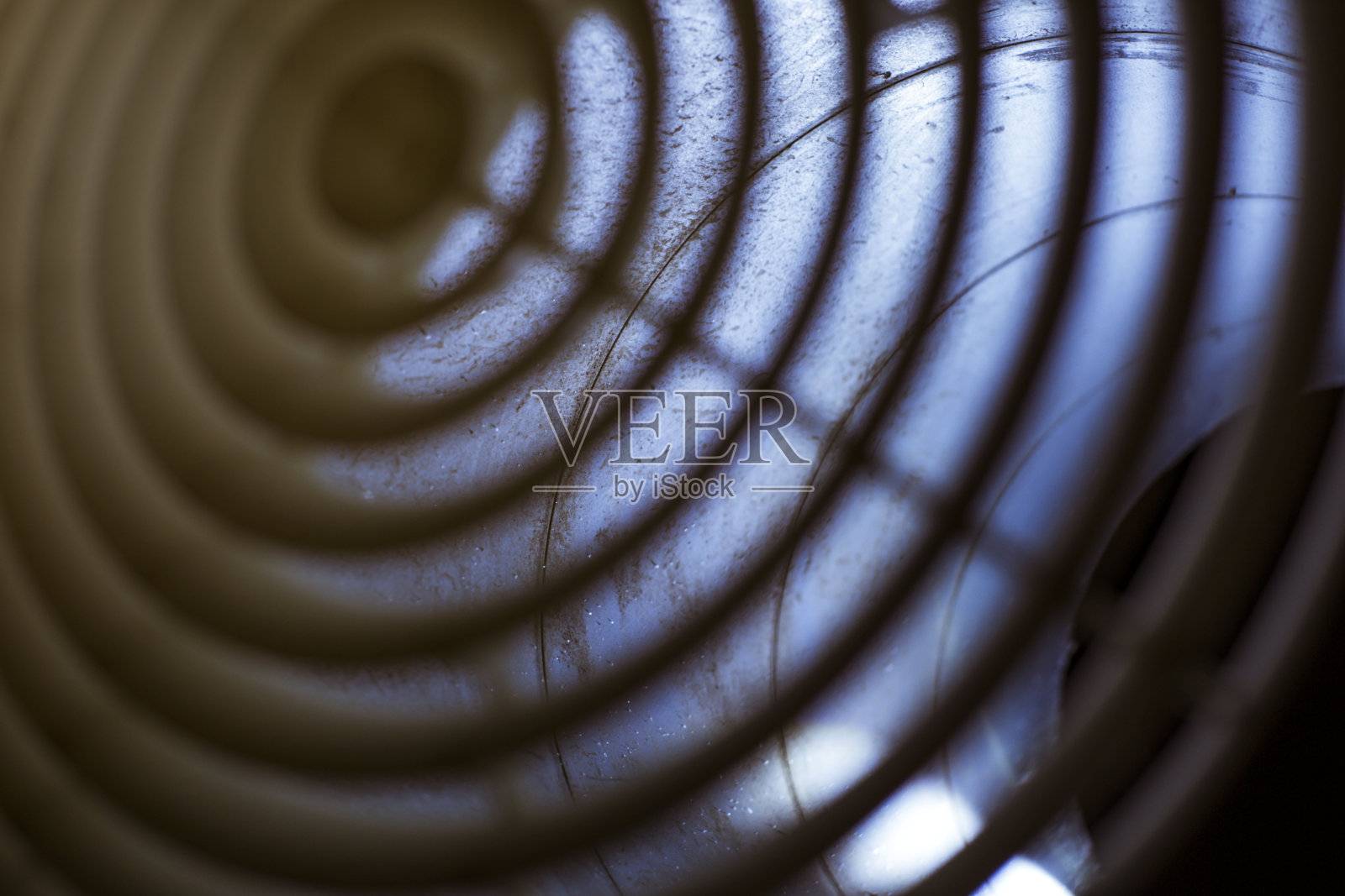 通风格栅扩散器的特写安装在夜间的风管，前面和背景是模糊的照片摄影图片