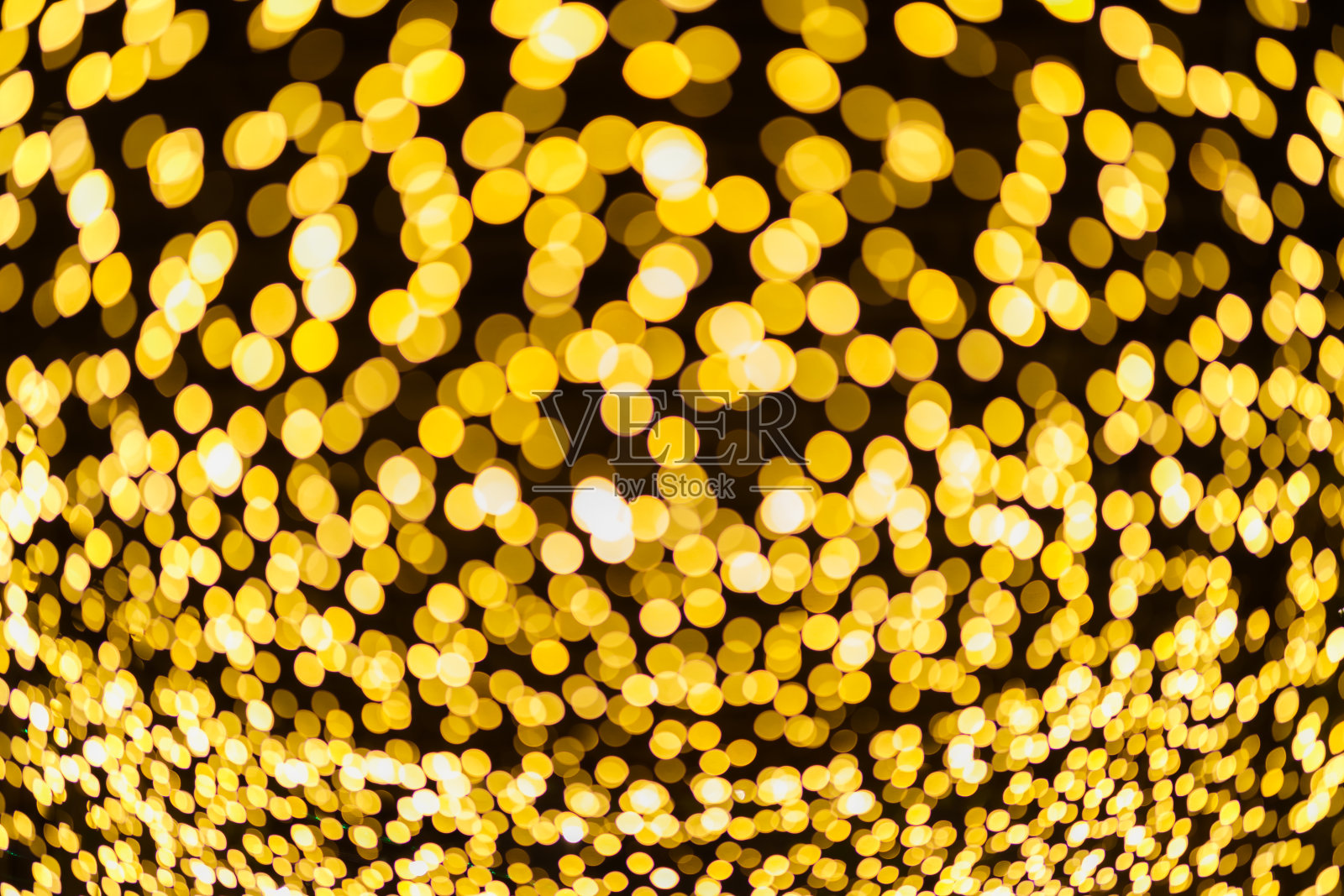 黄色彩色灯抽象的圆形散景圣诞树背景装饰在圣诞节和新年。照片摄影图片