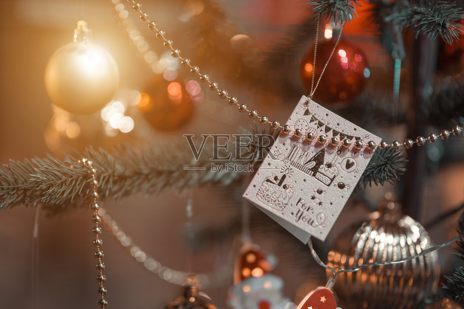 圣诞快乐，彩色球，礼品盒和圣诞问候图片包裹装饰在绿色圣诞树背景装饰在圣诞节和新年。照片摄影图片