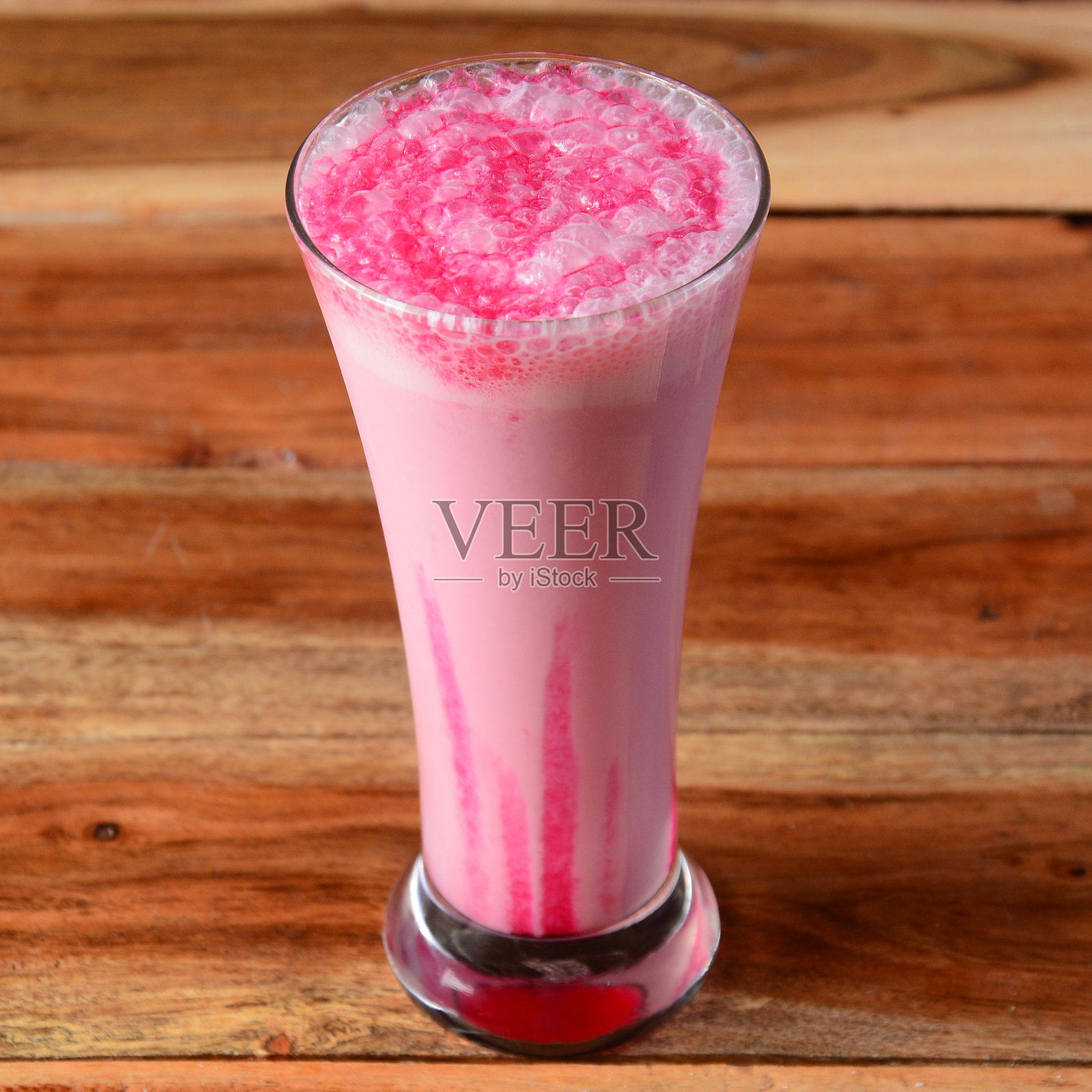 草莓奶昔在一个乡村的木制背景上的玻璃杯，一个清爽的夏日饮料，选择性的焦点在上面照片摄影图片