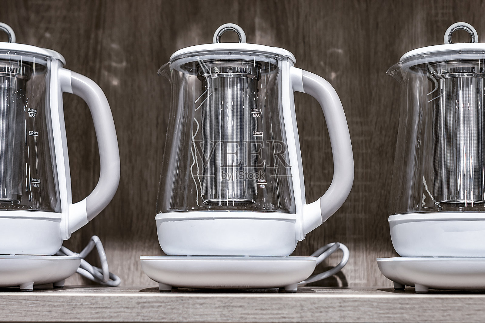 电白水壶。站成一排。在棕色的背景上。从前面看。照片摄影图片