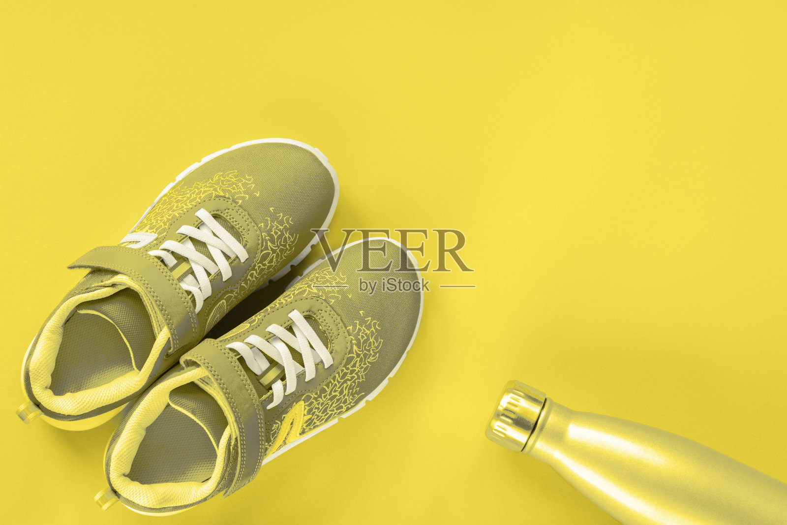 灰色运动鞋和瓶子与水在黄色的背景。健康生活理念，运动训练，俯视图照片摄影图片