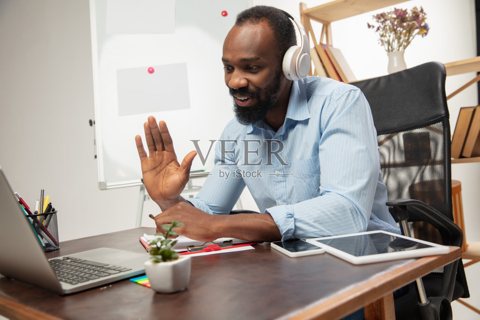 在线英语课程在家。微笑的男人在客厅里远程教学生照片摄影图片
