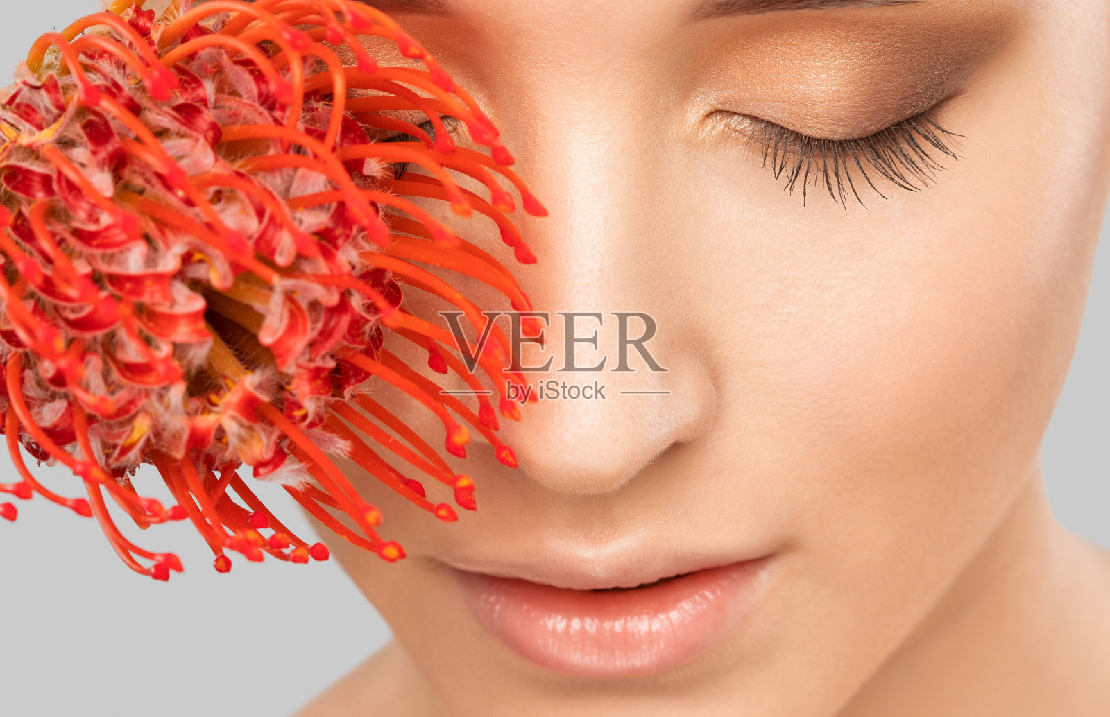 一个迷人的女孩的肖像与花，化妆，葱郁的眉毛和丰满的嘴唇。个人护理、美容和化妆概念。照片摄影图片