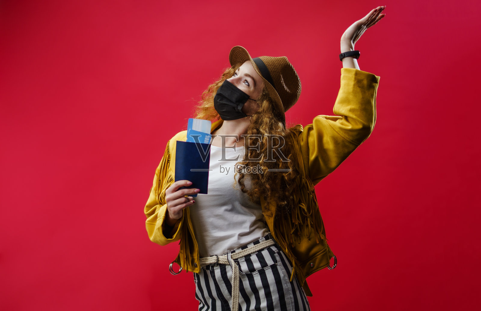 年轻女子在演播室拿着机票、冠状病毒和旅行概念。照片摄影图片