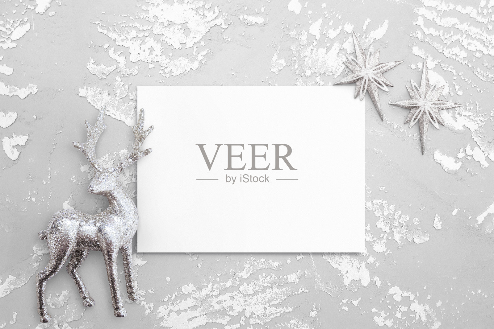 由银色装饰鹿、星星、水彩纸组成的白色混凝土背景。新年和圣诞节快乐的板，海报模型为您的设计。平铺，俯视图，拷贝空间照片摄影图片