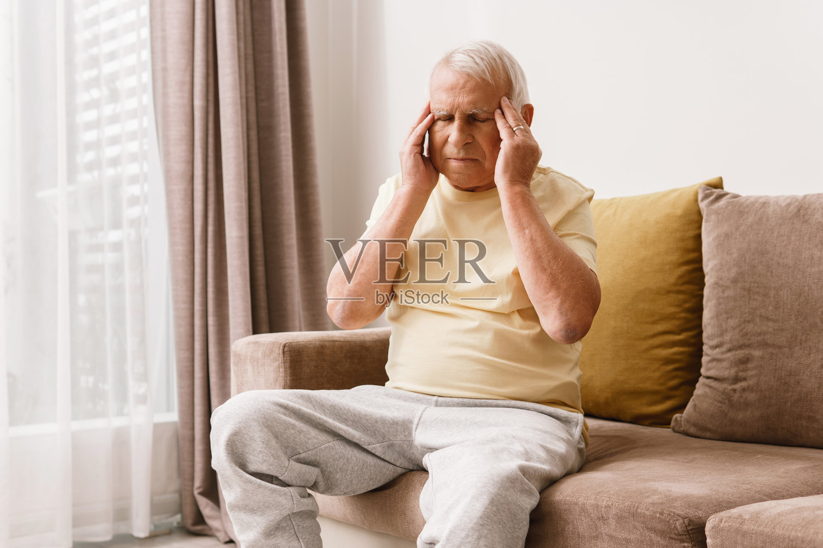 一位老人正饱受头痛之苦照片摄影图片