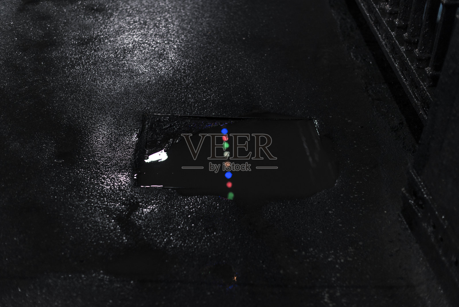 多色灯光反射在污水坑的水坑上照片摄影图片