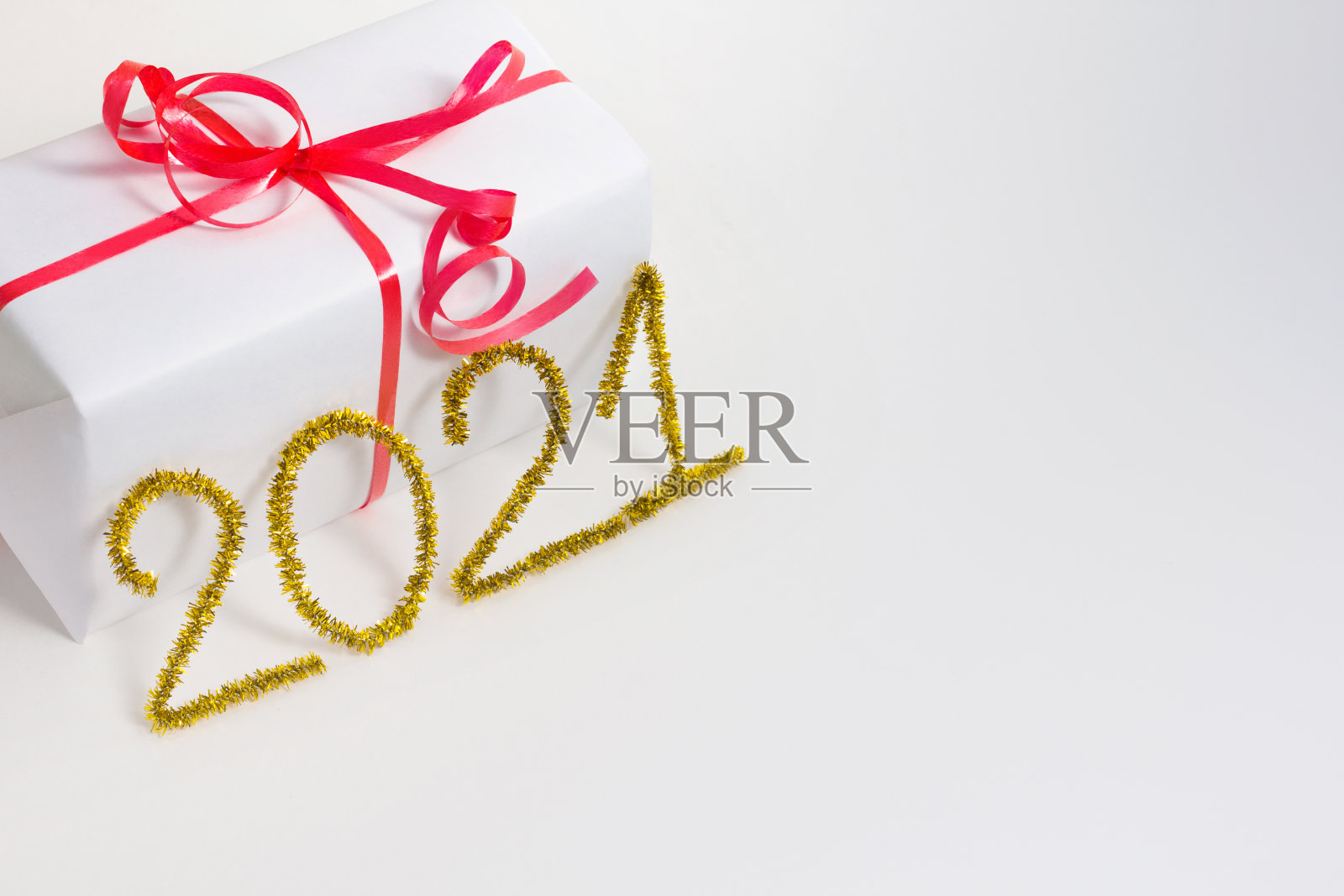 2021号为新年贺卡。圣诞礼物装饰在白色的背景。金色的金属丝。照片摄影图片