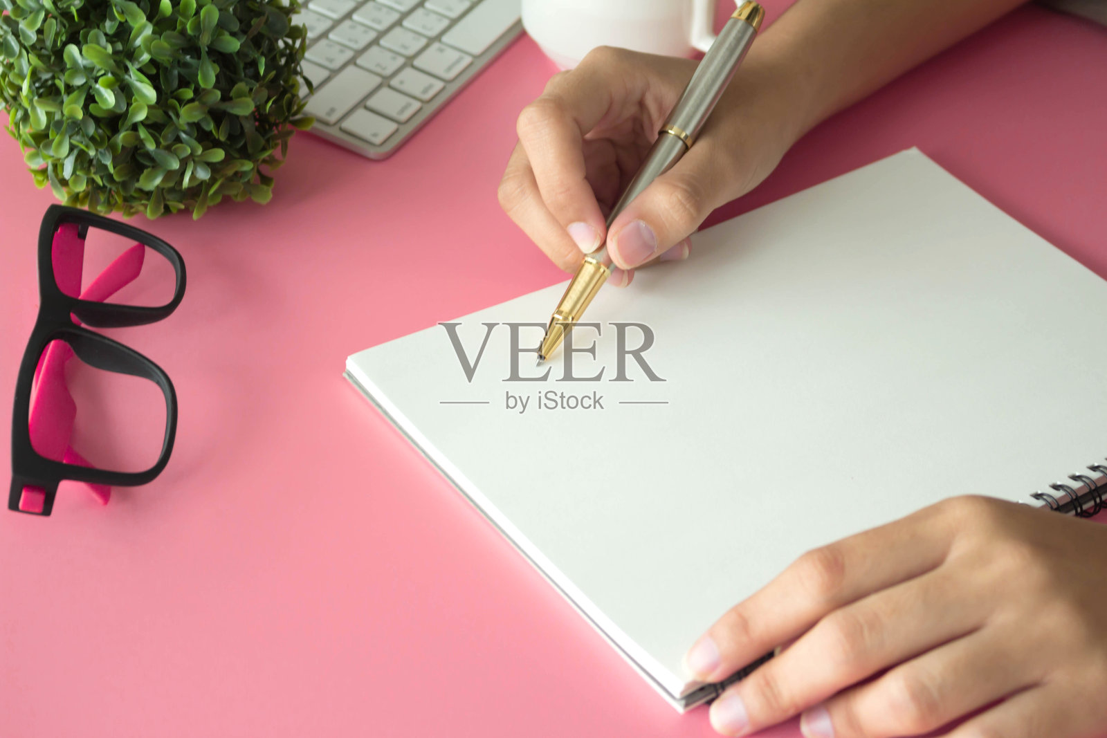 现代粉色办公桌，中间有笔记本输入文本。俯视图，平放照片摄影图片