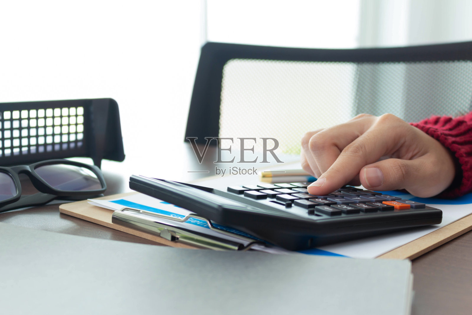 拿着计算器的女人钱已经算好了。照片摄影图片