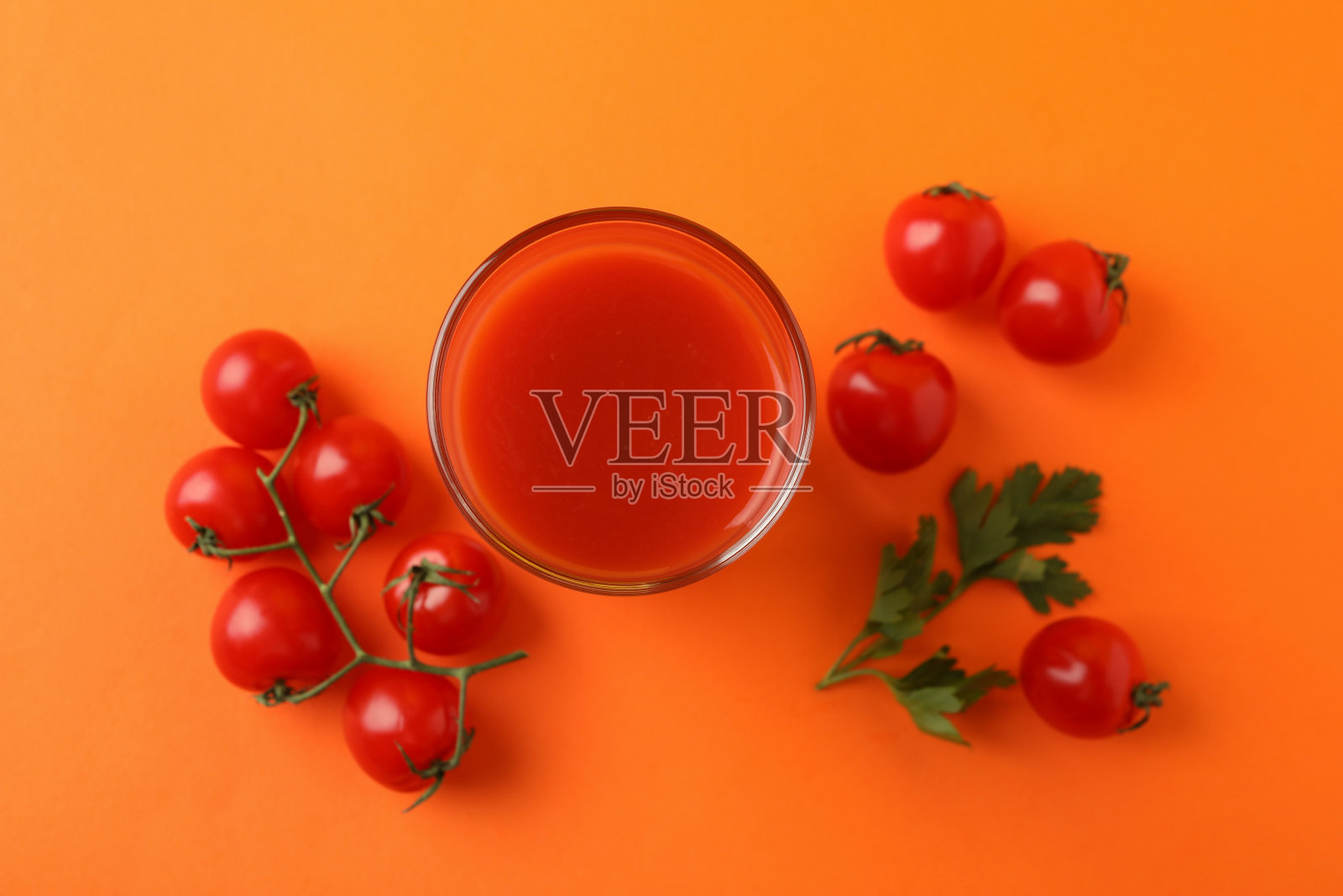 一杯番茄汁和橙色背景的西红柿照片摄影图片