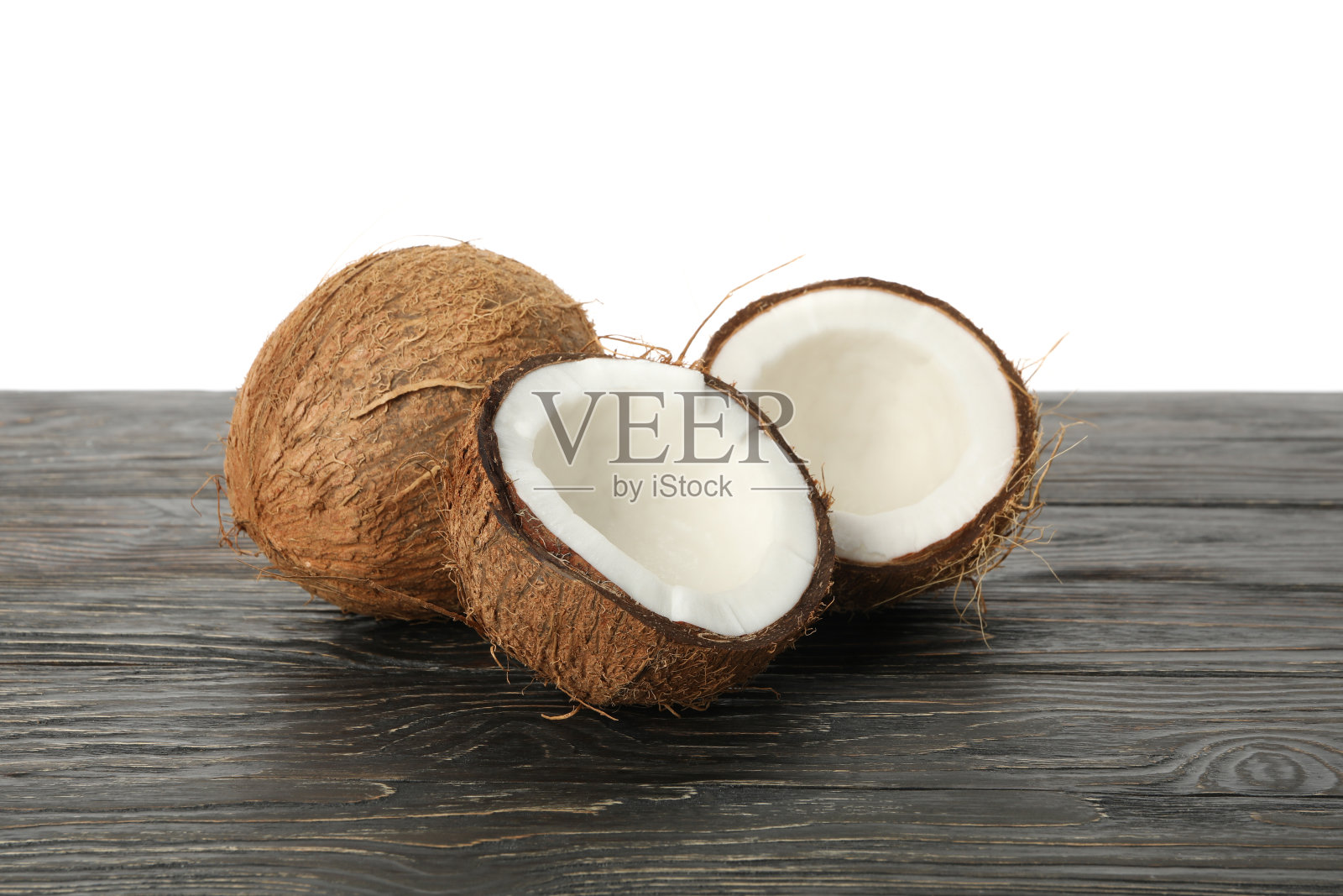 木桌上放着新鲜的椰子，白色的背景上显得孤立照片摄影图片
